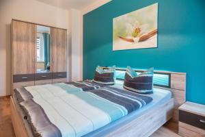 a bedroom with blue walls and a bed with pillows at Ferienwohnung Romy in Naumburg