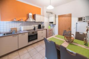 a kitchen with a table and a refrigerator at Ferienwohnung Romy in Naumburg