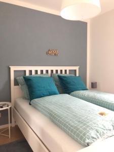 a bedroom with two beds with blue pillows at Wohlfühl-Apartment Sinsheim, Nähe Therme und Museum in Sinsheim