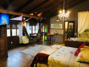Un dormitorio con una cama grande y una lámpara de araña. en Shiva Guest House en Florianópolis