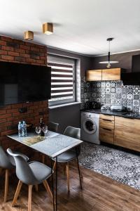 a kitchen with a table and chairs in a room at Apartament Chillout in Ustrzyki Dolne