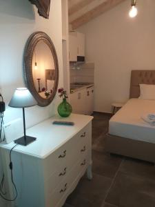 a bedroom with a dresser with a mirror and a bed at Sunrise Studio in Skala Kallirachis