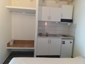 a small kitchen with white cabinets and a sink at Sunrise Studio in Skala Kallirachis