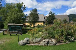 a garden with a bench and flowers in front of a building at Urlaub am Bio-Bauernhof Liebchen in Zeutschach