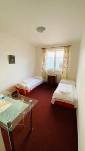 a room with two beds and a table and a window at Hotel Swami in Mělník