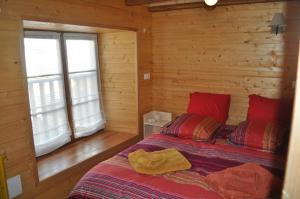 een slaapkamer met een bed in een blokhut bij Eco Gite La Grange in Fos