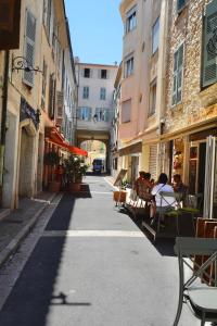 an empty street with people sitting in chairs in an alley at Old Town Antibes Apartment in Antibes