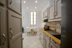 a kitchen with white cabinets and a table at Old Town Antibes Apartment in Antibes