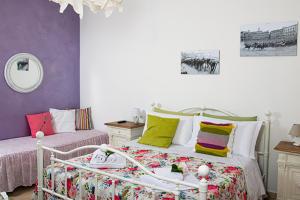 een slaapkamer met een bed met kleurrijke kussens bij B&B Le Camere di Livia in Siena