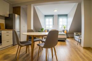 a kitchen and dining room with a table and chairs at APARTAMENTY CENTRUM in Braniewo +14 photos