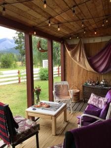 a screened in porch with a table and chairs at Rose Cottage Bed & Breakfast in Valemount