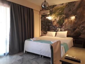 Habitación de hotel con 2 camas y pared de piedra en Enalion Beach Hotel, en Paralio Astros