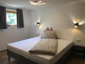 ein großes Bett in einem Zimmer mit zwei Leuchten in der Unterkunft Ferienwohnung Stoablick - barrierefrei mit Bergblick in Bad Goisern