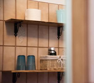 a shelf with cups and a basket on it at Rooms Malina in Blejska Dobrava
