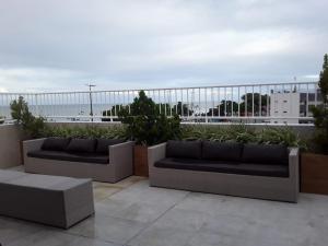 dois sofás sentados numa varanda com o oceano ao fundo em Hotel Costa do Atlântico em João Pessoa