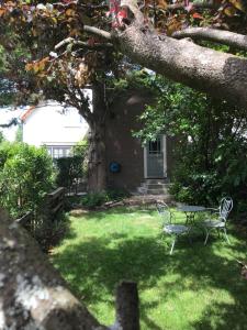 a table and chairs in a yard with a tree at Studio Het Kommertjeshof in Burgh Haamstede