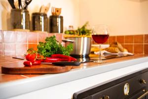 un bicchiere di vino rosso accanto a un tagliere con verdure di ANTELMI LUXURY VILLA a Firà