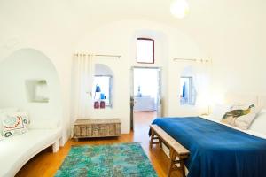 biała sypialnia z niebieskim łóżkiem i kanapą w obiekcie ANTELMI LUXURY VILLA w Firze +19 zdjęć