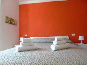 布魯尼亞托的住宿－Affittacamere SveMilla，一张带白色枕头的床和橙色墙壁