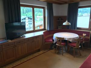 Una sala de estar con una mesa y un televisor. en Das Anja Sunleit`n, en Filzmoos