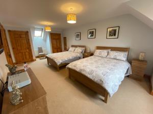 a bedroom with two beds and a table at Grangeview House in Grange