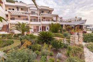 a building with a garden in front of it at Adriatic Apartment in Ulcinj