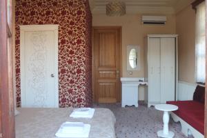 um quarto com uma cama e uma parede vermelha em Yalı Butik Otel em Buyukada