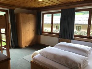 a bedroom with two beds and two windows at Das Anja Sunleit`n in Filzmoos