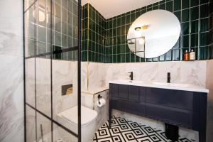 a bathroom with a toilet and a sink and a mirror at Maison Parfaite LS1 - Luxury City Centre Suites in Leeds
