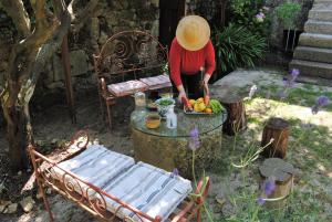 una persona en un sombrero de pie junto a una mesa en Casa de Cerqueda en Celorico de Basto