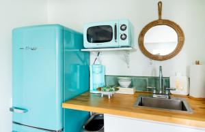 a blue kitchen with a sink and a microwave at Royal Palms Motel in Tybee Island