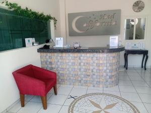 a bar in a room with a red chair at Hotel California in Tuxpan de Rodríguez Cano