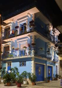 un bâtiment bleu avec des balcons et des plantes en pot dans l'établissement Mare Nostrum luxury suite, à Mazzeo