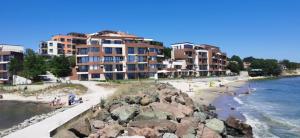 a beach with some buildings and people on the sand at Апартаменти и студия в комплекс Акротирия in Nesebar