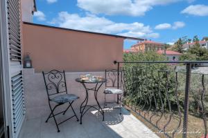 a small balcony with a table and chairs on it at Penthouse Leonarda with private parking in Pula