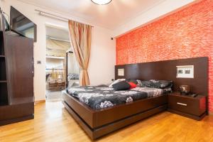 a bedroom with a large bed and a brick wall at Zezi in Athens
