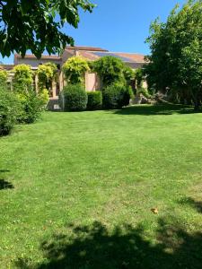 een tuin met groen gras en een huis bij Ca'Bert Villa dei Glicini in Castelnuovo del Garda