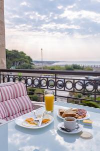 una mesa con dos platos de comida y un vaso de zumo de naranja en Adriatic Apartment, en Ulcinj