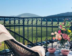 a table with a vase of flowers on a balcony at Zlatibor Hills Star Wellness & Spa in Zlatibor