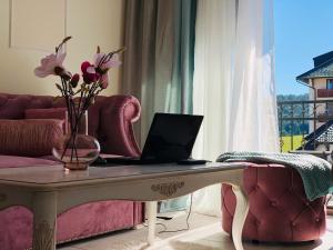 a living room with a table with a laptop on it at Zlatibor Hills Star Wellness & Spa in Zlatibor