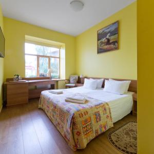 um quarto com uma cama, uma secretária e uma janela em In Astra em Vilnius