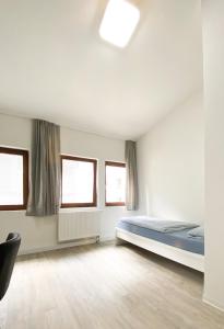 a bedroom with a bed and two windows at Traumhaftes Privatzimmer in Karlsruhe in Karlsruhe