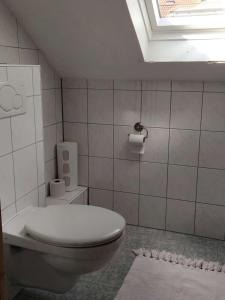 Haus Holzheimer في باد كيسينغن: حمام ابيض مع مرحاض ونافذة