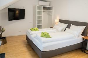 1 Schlafzimmer mit 2 weißen Betten in einem Zimmer in der Unterkunft City Apartments FN L8 KLIMATISIERT in Friedrichshafen