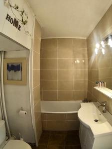 een badkamer met een wastafel, een toilet en een bad bij Joli Studio à la Montagne in Auron