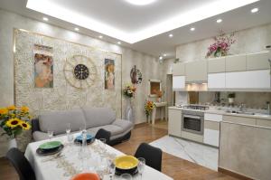 eine Küche und ein Wohnzimmer mit einem Tisch und einem Sofa in der Unterkunft CASERTA DELUXE BIS in Caserta