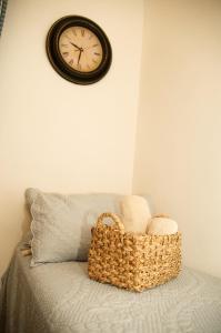 a clock on a wall above a bed with a basket at B&B del Giglio in Cefalù