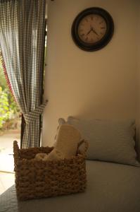 a clock on the wall above a basket on a bed at B&B del Giglio in Cefalù