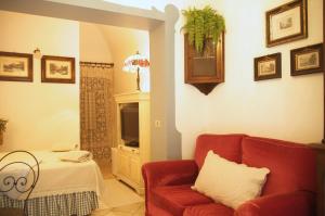 a living room with a red couch and a television at B&B del Giglio in Cefalù