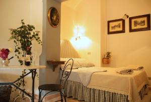 a bedroom with a bed and a table with a chair at B&B del Giglio in Cefalù